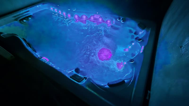 Swim spa lit blue at night with the jets running